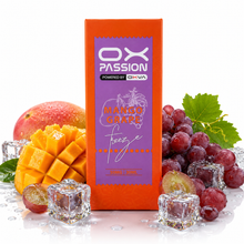 An orange and purple OX PASSION Freeze vape juice box labeled Mango Grape flavor, surrounded by fresh mango slices, red grapes, a mango pit, and clear ice cubes on a white reflective surface.
